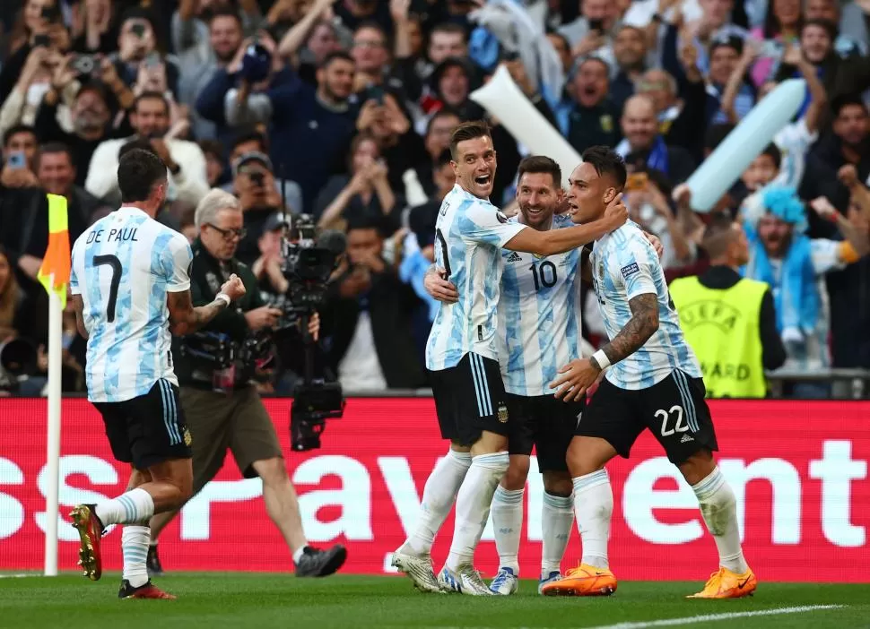 ABRIÓ EL CAMINO DE LA VICTORIA. Lautaro Martínez (22) ya marcó el primer tanto “albiceleste” y lo festeja con Messi y Lo Celso. De Paul se suma a la celebración. 
