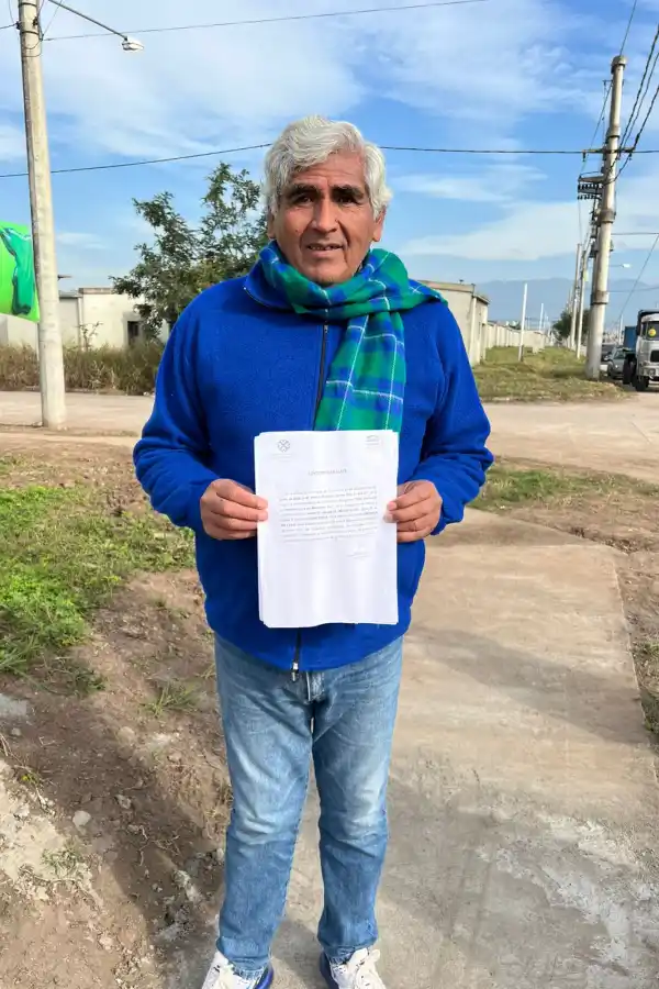 Don Rolando Ponce exhibe la documentación oficial de su vivienda. 