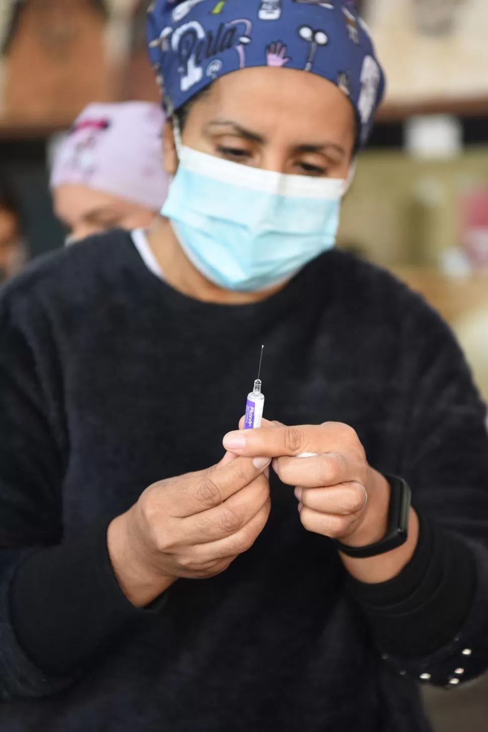 LISTA. Una enfermera enseña la vacuna antes de colocarla. 