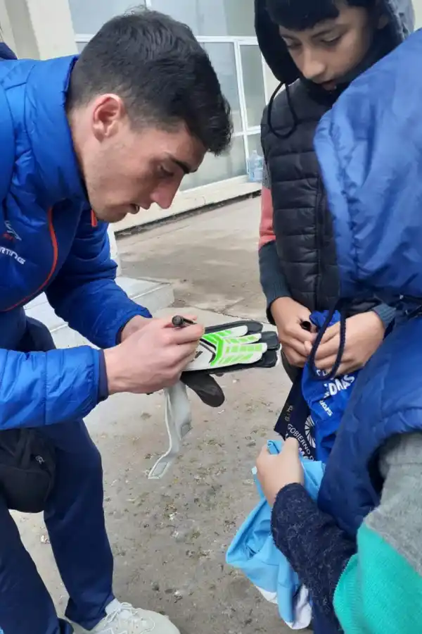 SOLICITADO. Luego de la práctica de ayer Marchiori (titular hoy) se sacó fotos y le firmó los guantes a Dylan, hincha “decano”. 
