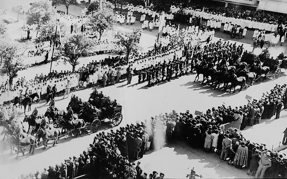1949. Las tropas marchan por la plaza Independencia, flanqueadas por estudiantes primarios y secundarios. Del otro lado de la calle, la mutltud se apiña para ver el desfile. 