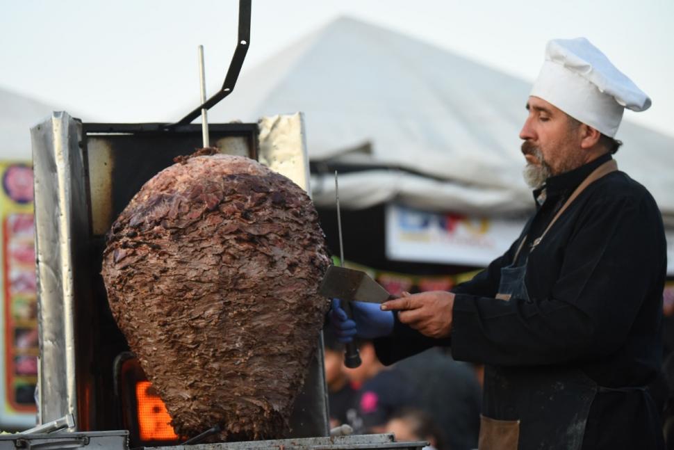 COCINANDO. El cocinero, instrumentos en mano, desmenuza la carne con paciencia y pericia antes de preparar un shawarma.