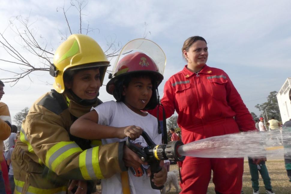 JUGANDO A CRECER PARA ESTAR AL SERVICIO DE LA COMUNIDAD. Aunque el adagio popular pretende que “de jóvenes somos incendiarios y de adultos somos bomberos”, los niños de Concepción invirtieron ese papel en la Terminal de Ómnibus. Los bomberos les enseñaron a manejar sus equipos.