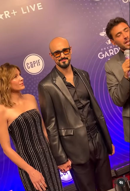 ABEL PINTOS. Anteojos ahumados y cuero negro, de la mano de Mora Calabrese, su esposa, de strapless bordado en piedras.