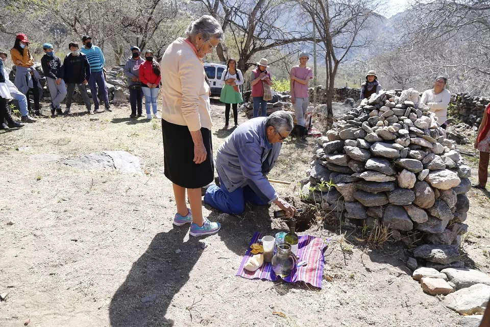 EN LA  MONTAÑA. Ante una apacheta, la comunidad indígena de Talapazo realizó ofrendas a la Pachamama. FOTOs DE medios.unt.edu.ar