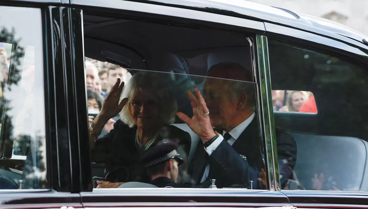 PRIMERAS DECISIONES. El Rey Carlos junto a Camilla saludan a la salida del Palacio de Buckingham.