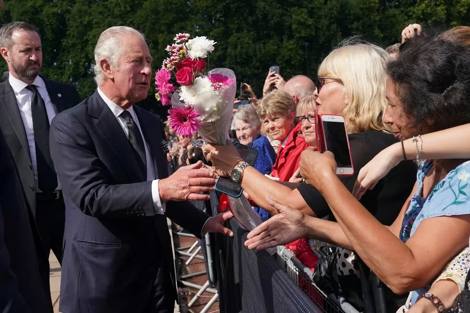 El rey Carlos III es recibido por ciudadanos durante un paseo para ver los tributos dejados fuera del Palacio de Buckingham, Londres. Foto de Reuters