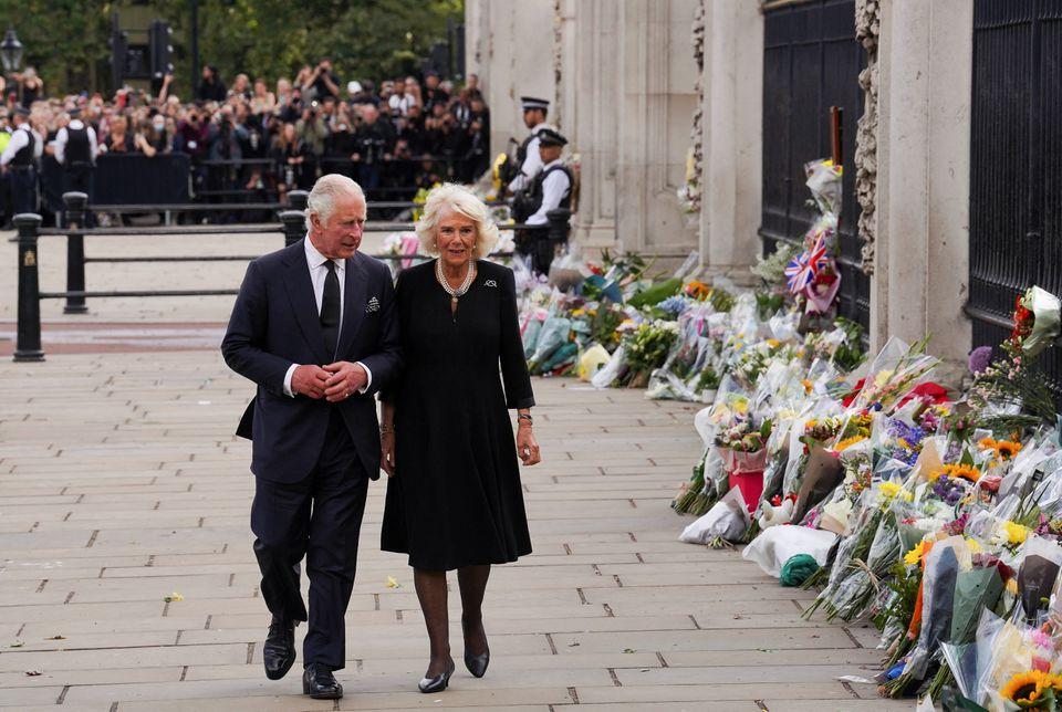 El rey Carlos y la reina Camila de Gran Bretaña caminan a lo largo de la valla del Palacio de Buckingham, tras el fallecimiento de la reina Isabel. Foto de Reuters