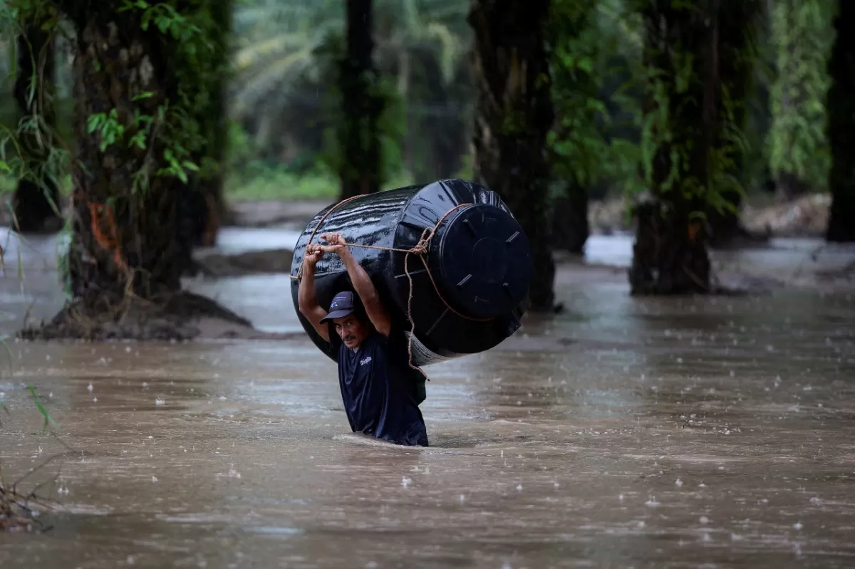 CICLÓN JULIA. Un hombre camina con el agua por encima de la cintura en Honduras.
