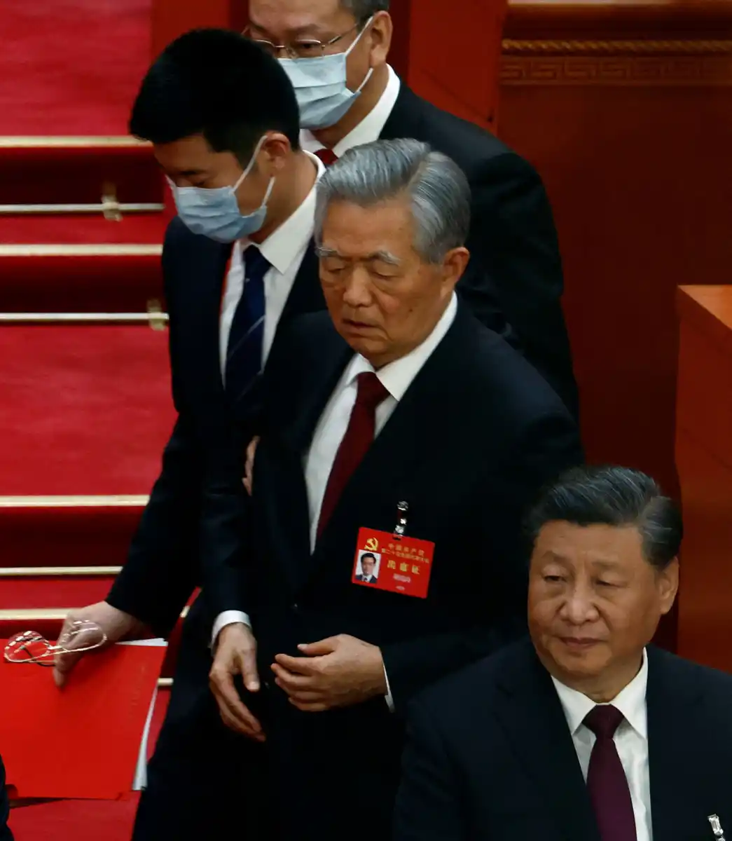 LA SALIDA. Hu Jintao es escoltado ante la indiferencia de Xi Jinping en el Congreso del Partido Comunista Chino.