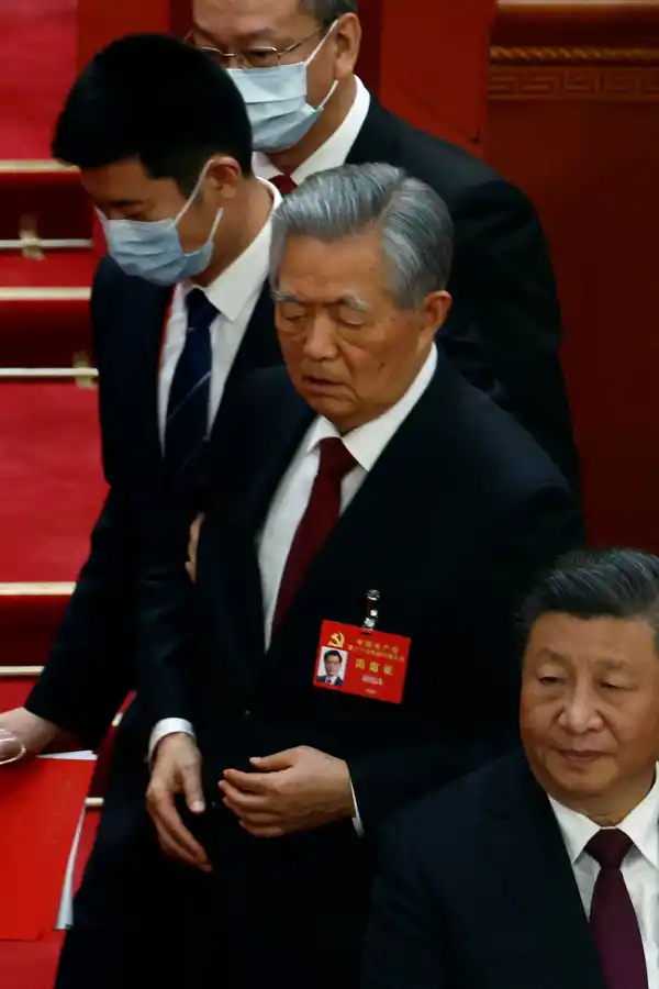 LA SALIDA. Hu Jintao es escoltado ante la indiferencia de Xi Jinping en el Congreso del Partido Comunista Chino.