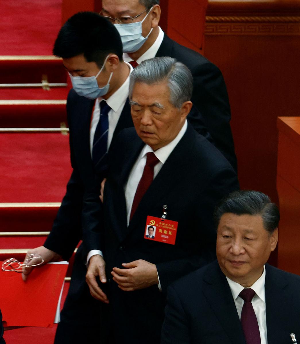 LA SALIDA. Hu Jintao es escoltado ante la indiferencia de Xi Jinping en el Congreso del Partido Comunista Chino.