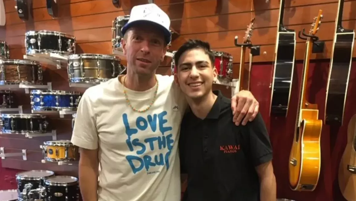 Chris Martin junto a uno de los vendedores del local de instrumentos