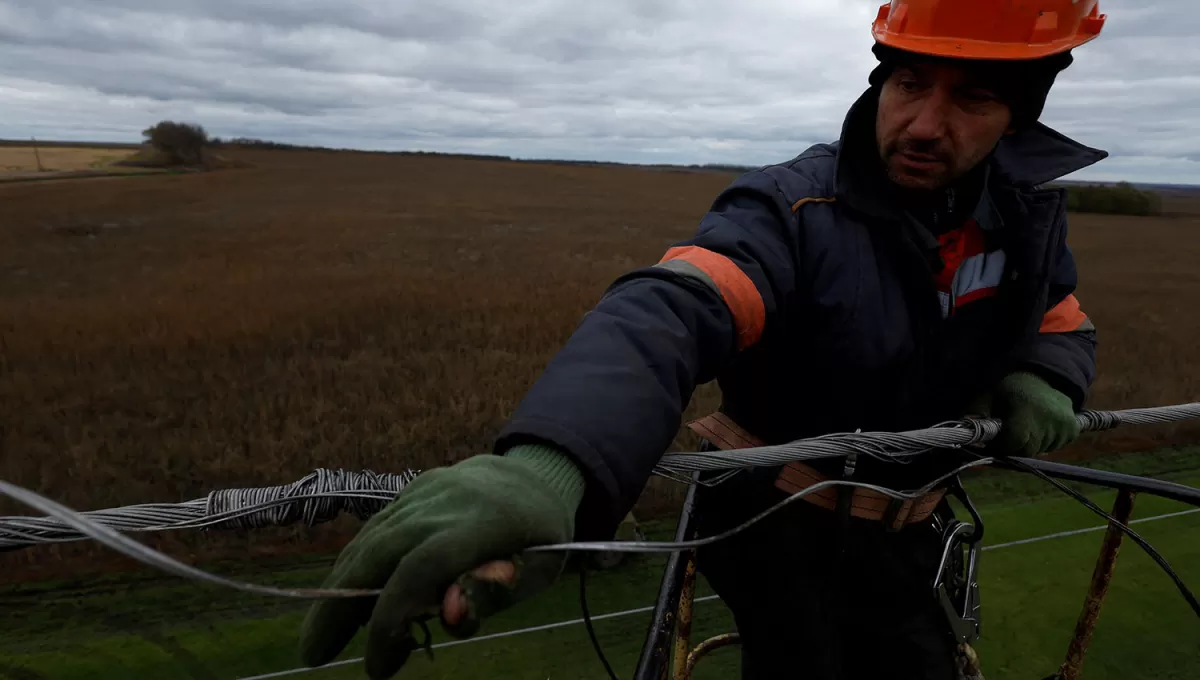 ALTA TENSIÓN. Un trabajador intenta reconectar una línea de electricidad en las afueras de Jarkov, en Ucrania.