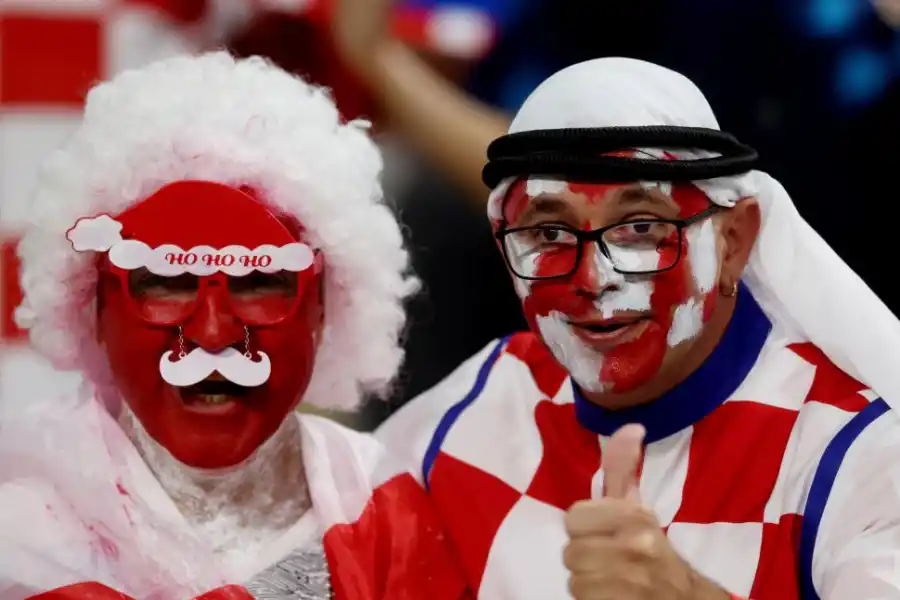 FELICES. Hinchas croatas, durante el partido en el que su selección goleó 4-1 a Canadá, mostraron esos típicos trajes que emulan las vestimentas de los jeques árabes, pero con colores de la bandera de su país. 