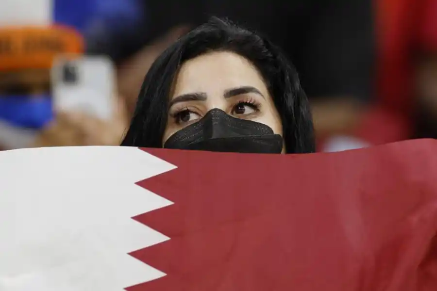 APOYO. Una hincha de Qatar sostiene una bandera durante el partido que su seleccionado perdió frente a Países Bajos. 