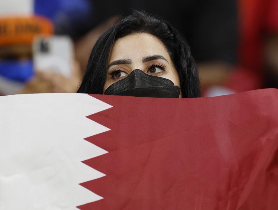 APOYO. Una hincha de Qatar sostiene una bandera durante el partido que su seleccionado perdió frente a Países Bajos. 