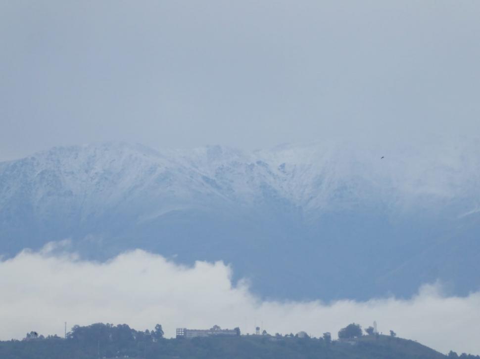 BLANCO. Así se  veía ayer la helada en los cerros del Aconquija, detrás de San Javier.Abajo, la granizada en Amaicha, a comienzo de semana. Hoy comienza a subir la temperatura. 