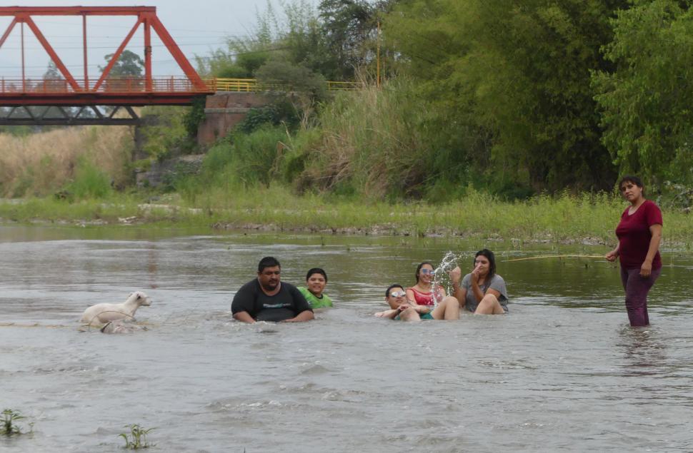 ALIVIO III. El río Medinas es contenedor frente a las altas temperaturas: ahí se refrescaba ayer la familia y también el perrito.