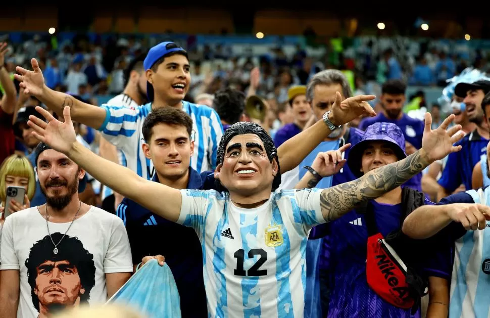 DIEGO POR DOS. Un hincha con la máscara de Maradona, a su lado, otro simpatizante tiene una remera de Diego.