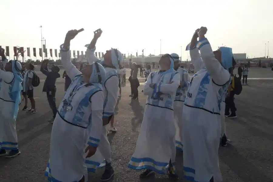 PARA ARRIBA. Los simpatizantes tratan de enfocar alguno de los aviones que sobrevuelan Lusail. 