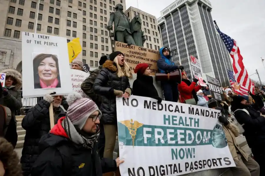 Manifestantes protestan contra las recomendaciones de las vacunas contra el coronavirus, durante una marcha con carteles frente al Capitolio de Albany, en Nueva York.