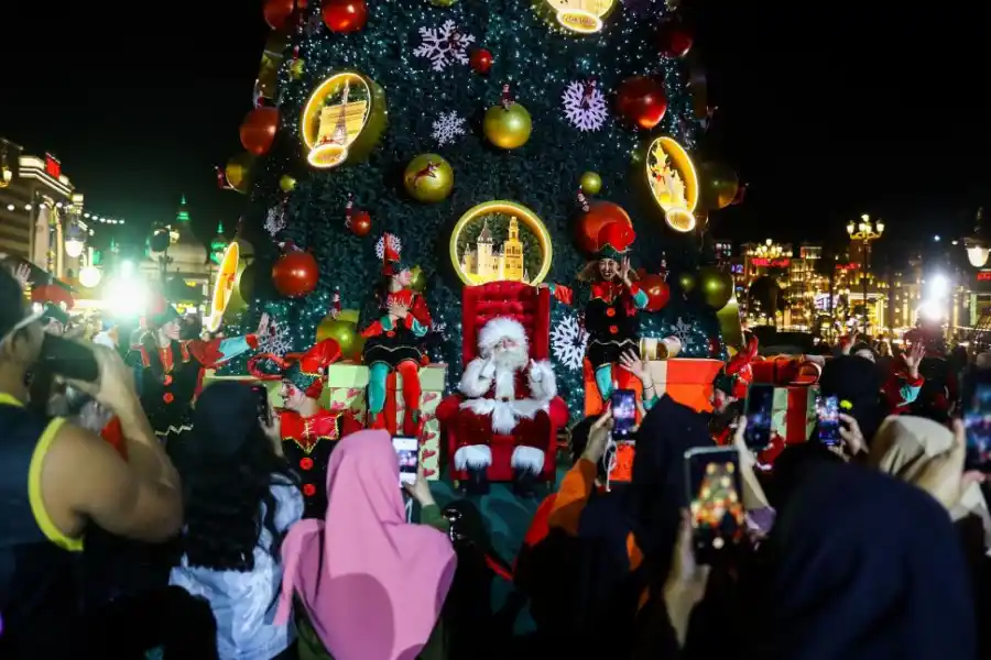 DE DUBAI A KIEV. Residentes de Emiratos Árabes (arriba) disfrutan de la decoración navideña,mientras que, en Ucrania (izquierda), se celebra en medio de los ataques rusos.  fotos reuters