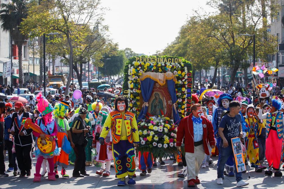 Cientos de personas, disfrazadas de payasos, marchan para rendir homenaje a la santa patrona de México, Nuestra Señora de Guadalupe, en la Ciudad de México.