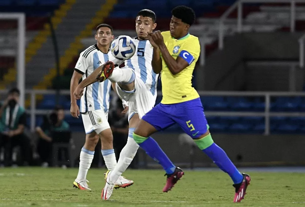 LOS DOS 5. El de argentina, González, intenta controlar la pelota. El de Brasil, Santos, pone toda la fuerza.  @argentina