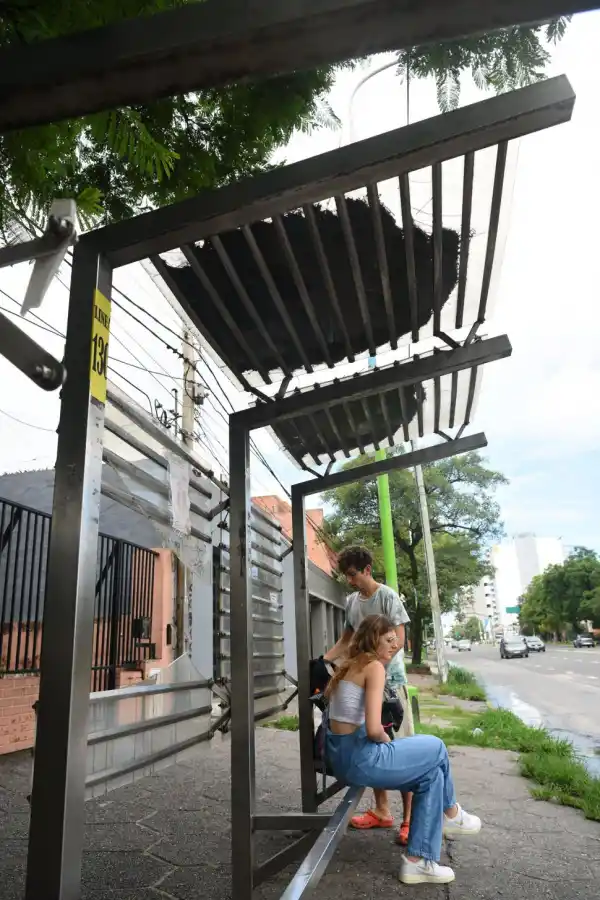 SI LLUEVE, SE EMPAPAN. Dos personas esperan el colectivo en    Mate de Luna al 2.200. El techo del refugio está destrozado. 
