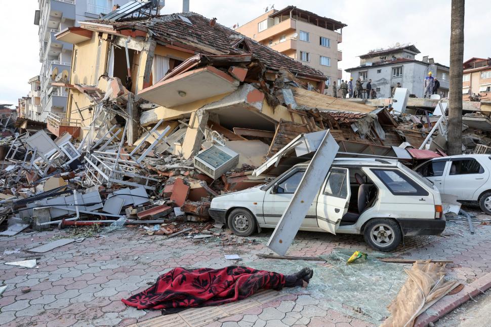 ESCOMBROS. (Arriba) Así quedaron las calles en Turquía. SOBREVIVIENTES. (Izq.) Dos personas buscan sobrevivientes en Hatay, Turquía.  fotos reuters 