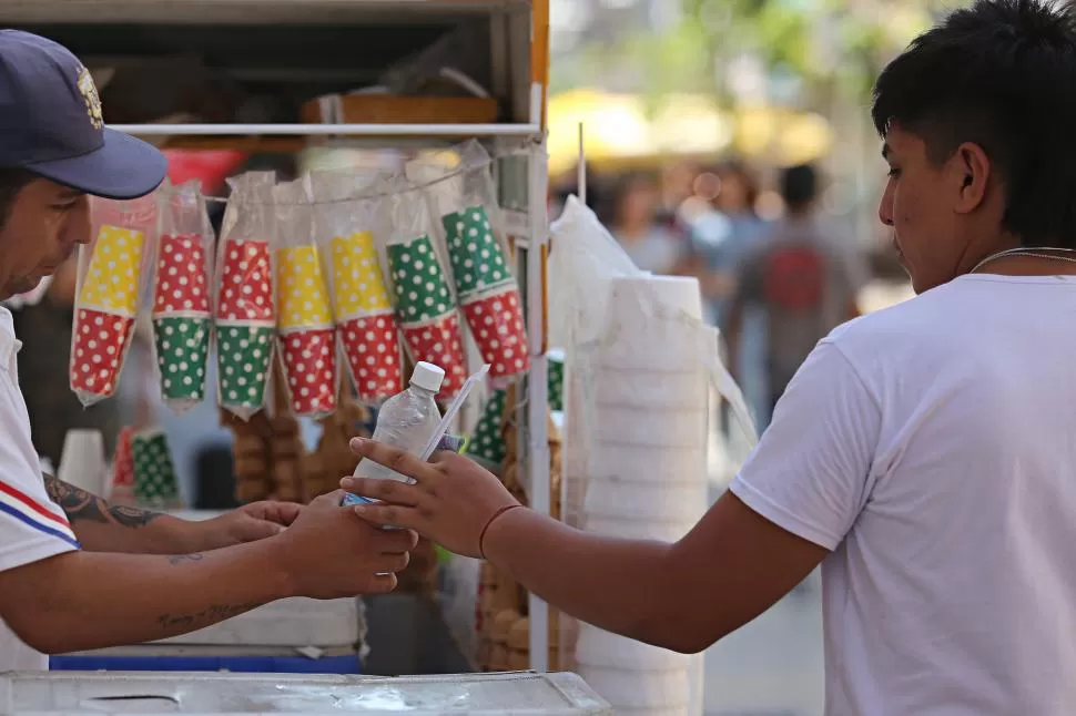 REFRESCO. Los vendedores ambulantes se las ingenian para sacar provecho del intenso calor ofreciendo botellas  de agua mineral. 