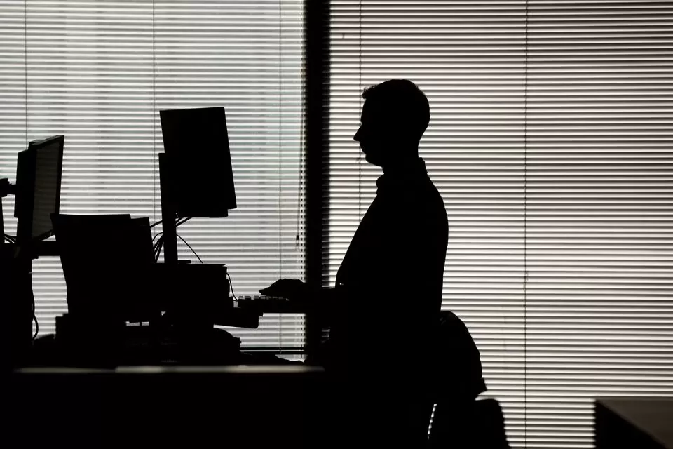 Un hombre trabaja en una computadora en un escritorio de pie en una oficina en el distrito financiero de Canary Wharf en Londres, Gran Bretaña, el 8 de febrero de 2023. 