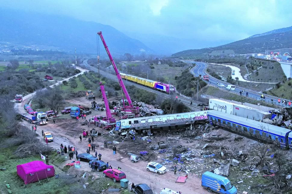 RESCATE Y BÚSQUEDA. Los rescatistas operan en el sitio del choque de dos trenes, cerca de la ciudad de Larisa, en el centro de Grecia.  