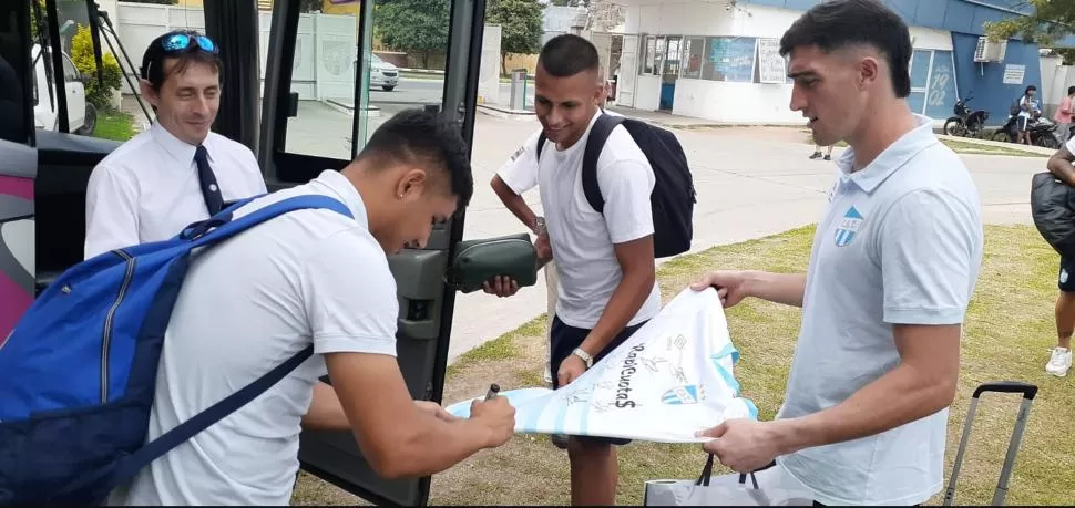 AUTÓGRAFOS. Moisés Brandán (será titular) firma la camiseta ante la mirada de “Tomi” Marchiori y “Guly” Lescano. 