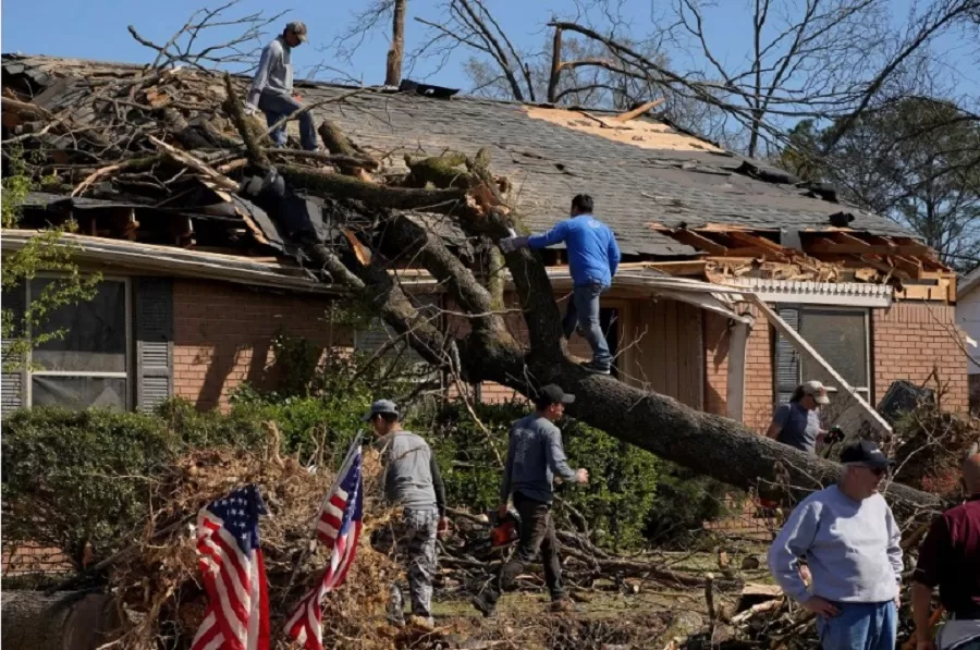 [1/11]  La gente trabaja para quitar un árbol que cayó sobre una casa, después de un tornado, después de que un monstruoso sistema de tormentas arrasara el sur y el medio oeste el viernes en Little Rock, Arkansas, EE. UU., 2 de abril de 2023. 