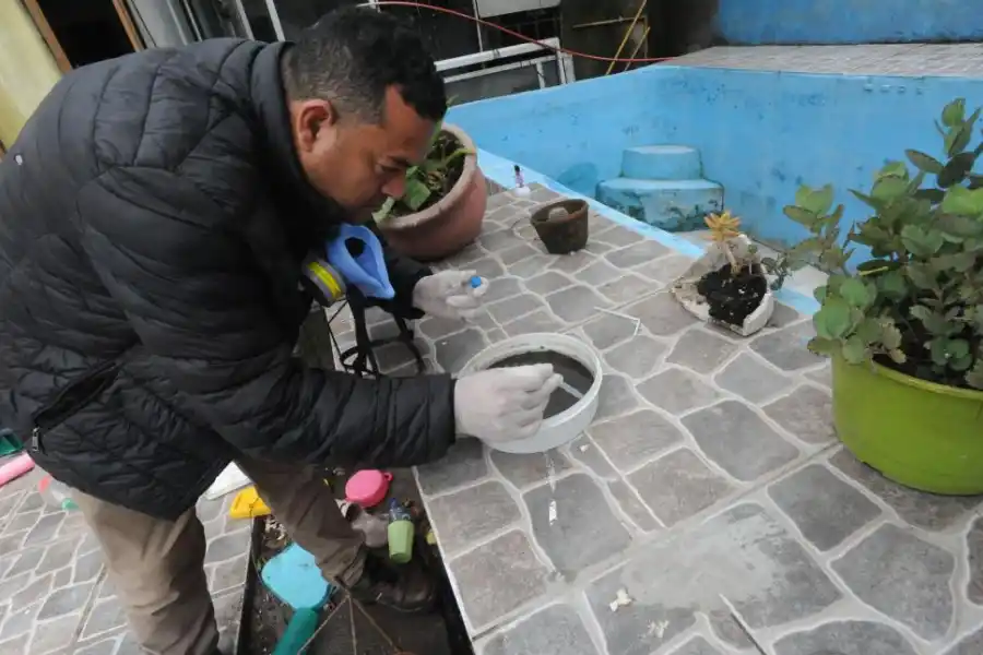 EN ACCIÓN. Un agente revisa si hay larvas de mosquito en un recipiente.  