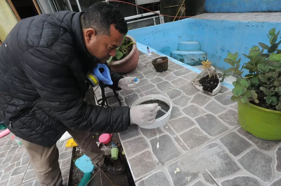 EN ACCIÓN. Un agente revisa si hay larvas de mosquito en un recipiente.  