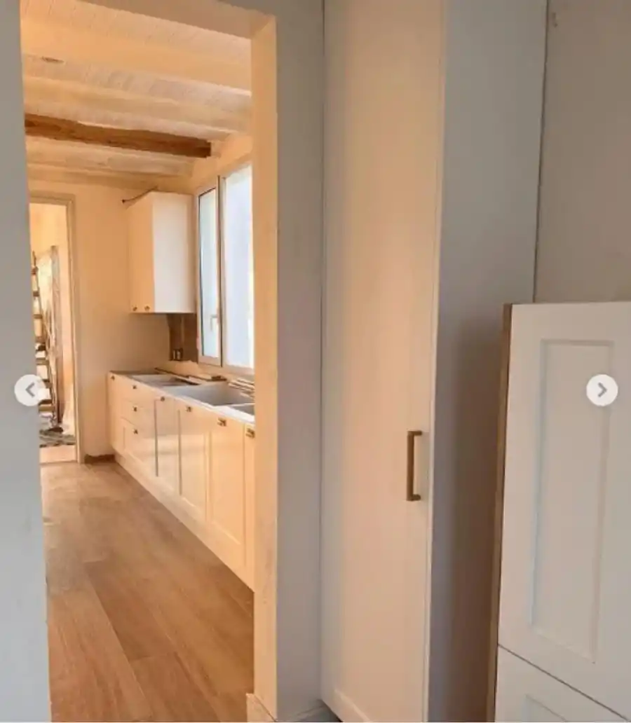 La cocina es bastante amplia y cuenta con muebles blancos.