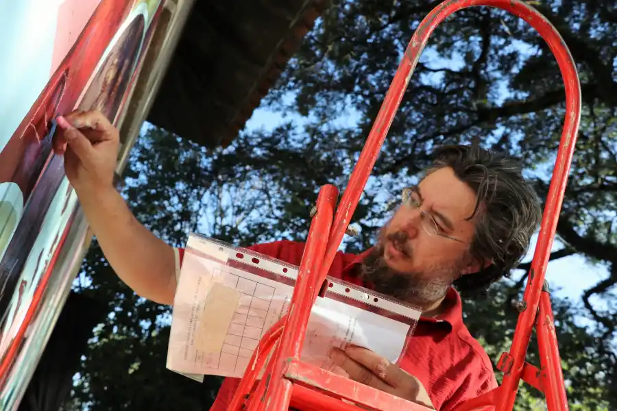 EN PLENO TRABAJO. Carrizo subido a una escalera, pintando un mural.