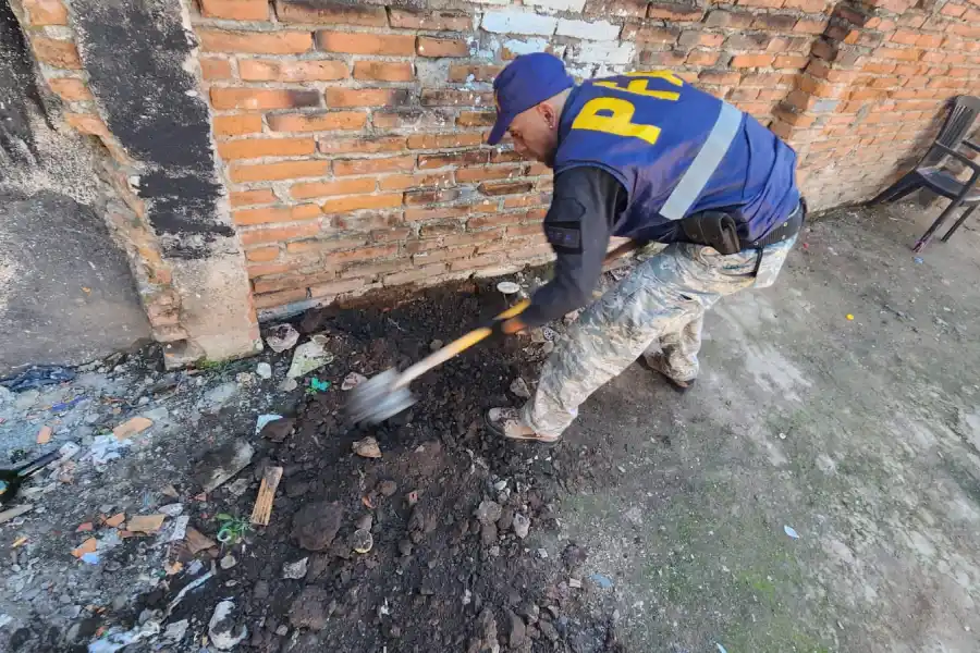 Un policía, con una pala, cava en uno de los sectores de la casa.