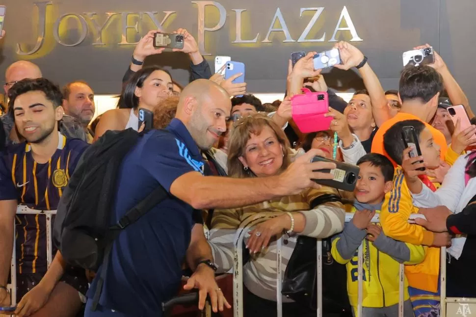  EFERVESCENCIA. Mascherano se toma selfies con los hinchas; en Santiago hay locura por la presencia del seleccionado.