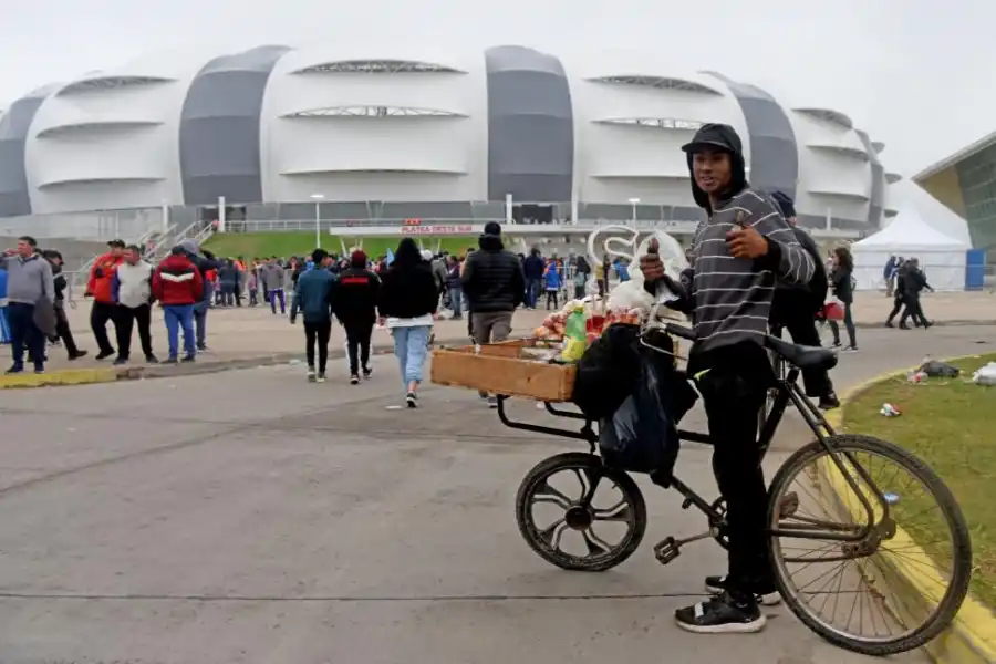 QUIOSCO MÓVIL. A bordo de su bicicleta, Damián Lobo es uno de los vendedores ambulantes que aprovechan el turismo mundialista para hacer unos pesos.
