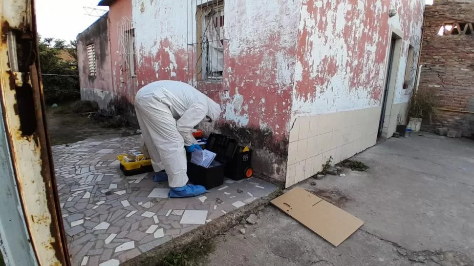 PREPARANDO EL EQUIPO. Un perito del ECIF se dispone a ingresar al fondo de la vivienda de Las Talitas donde encontraron el cuerpo de la víctima. 