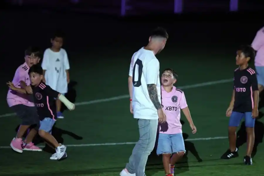 Lionel Messi habla con Mateo mientras Ciro, con el yeso, tira una gambeta. (Foto: AP)