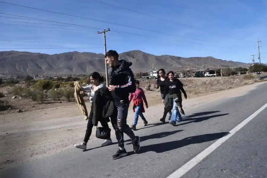 Las postales de familias caminando a la vera de la ruta son comunes.