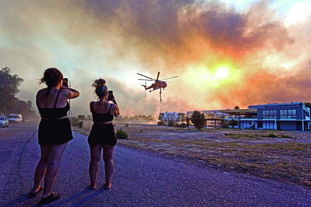 GRECIA. En la turística isla de Rodas, azotada por el fuego, los helicópteros de bomberos llenan tanques con el agua de las piletas de natación. 