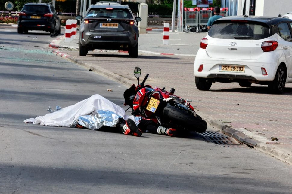 EN LA CALLE. El cuerpo de un motociclista quedó en el pavimento, en la ciudad de Sderot, en el sur de Israel, después de los ataques de Hamas.