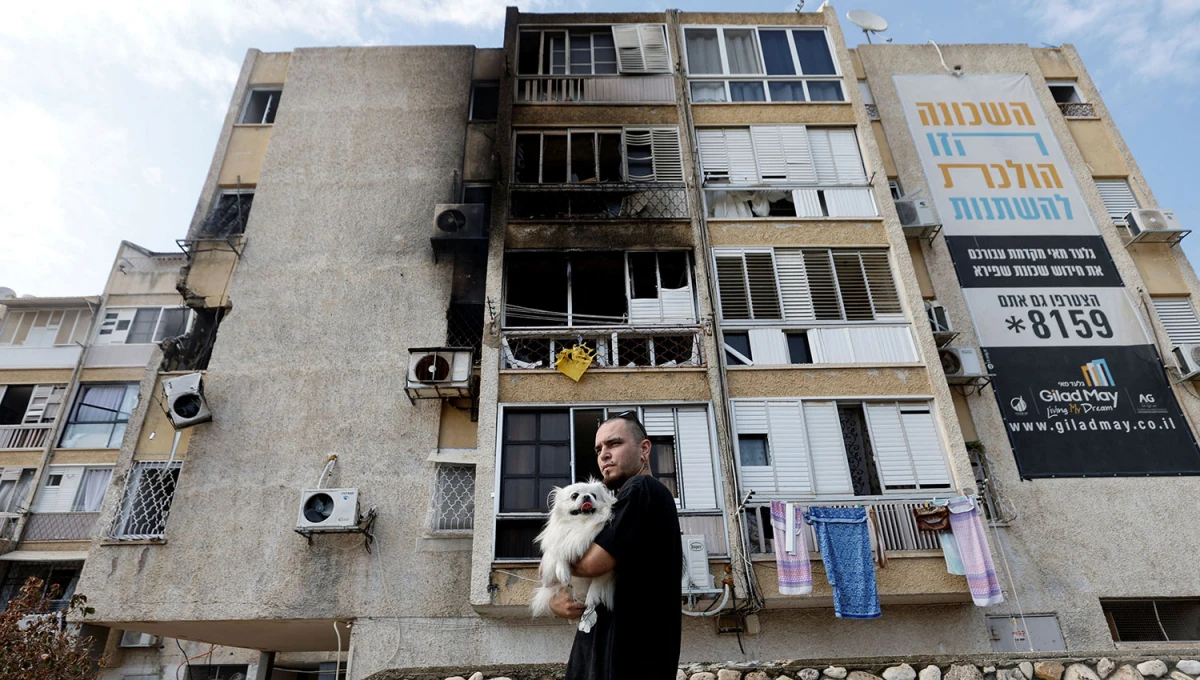 DESTRUCCIÓN Y DOLOR. Un hombre y su perro contemplan un edificio destruido en Ashkelon 