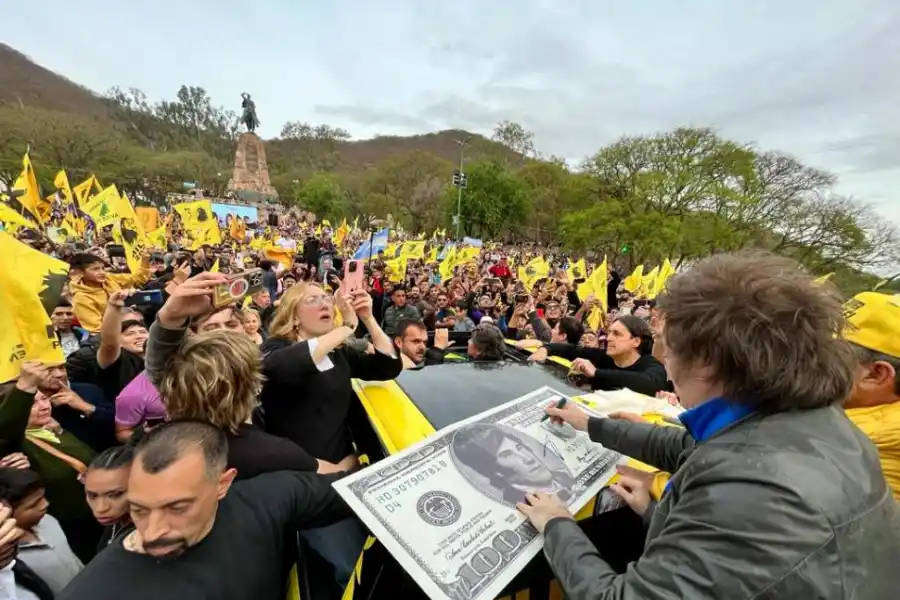 SELLO. El candidato libertario estampa su firma en la réplica de un dólar gigante que lleva impreso su rostro.